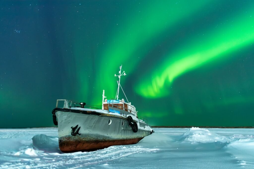 Nordlichter-Bootstour in Tromsø, Norwegen, mit Blick auf die Aurora Borealis über den arktischen Fjorden.